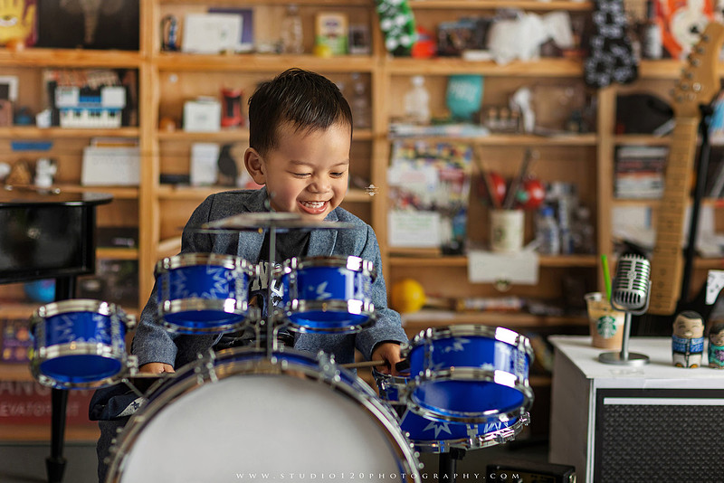 Two-year-old musician themed photo session inspired by NPR Tiny Desk, featuring a toddler holding an electric guitar in a studio music setting