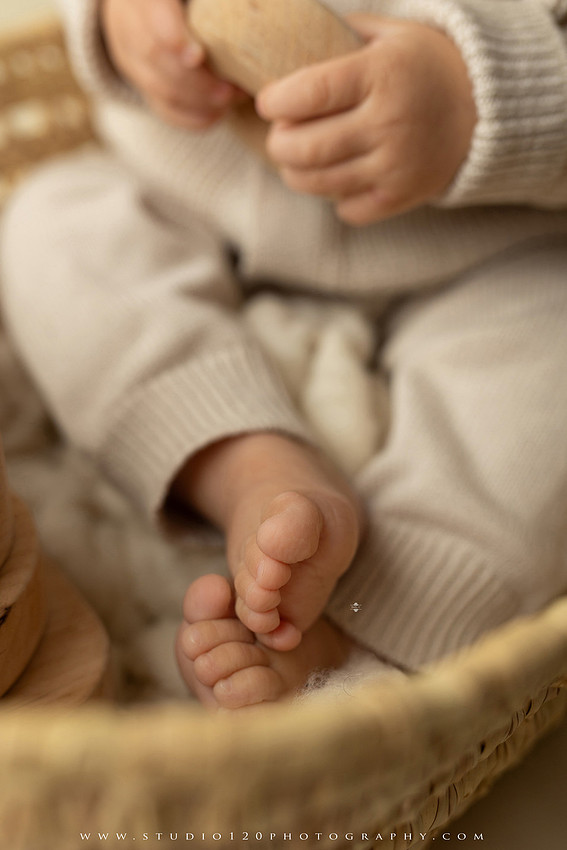 One-year-old baby wearing a cowboy hat sits on a rustic honky-tonk stage with vintage posters, string lights, and a neon “One Night Only” sign during a country-themed milestone photo session.