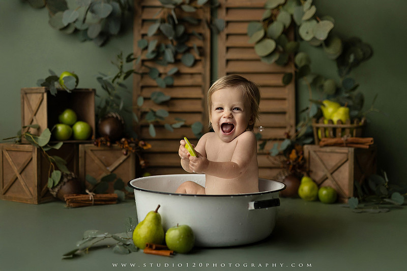EvotoOne-year-old baby wearing a cowboy hat sits on a rustic honky-tonk stage with vintage posters, string lights, and a neon “One Night Only” sign during a country-themed milestone photo session.