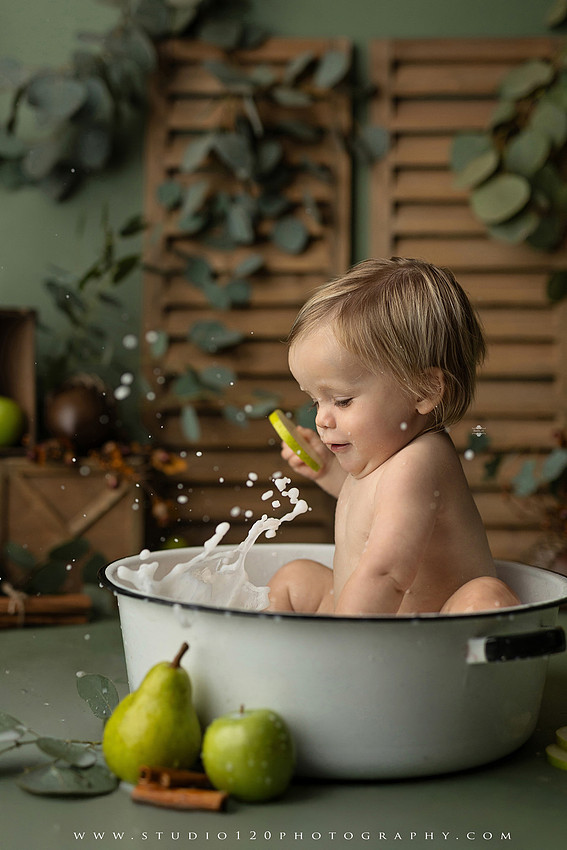 EvotoOne-year-old baby wearing a cowboy hat sits on a rustic honky-tonk stage with vintage posters, string lights, and a neon “One Night Only” sign during a country-themed milestone photo session.
