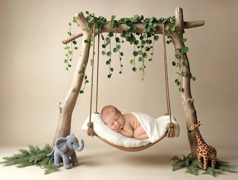 Custom newborn photography session in Ramona, California featuring a baby posed in cozy neutral tones with safari-inspired scenes, teddy bears, and a playful business suit setup, created using studio styling and digital backdrops by a San Diego newborn photographer.