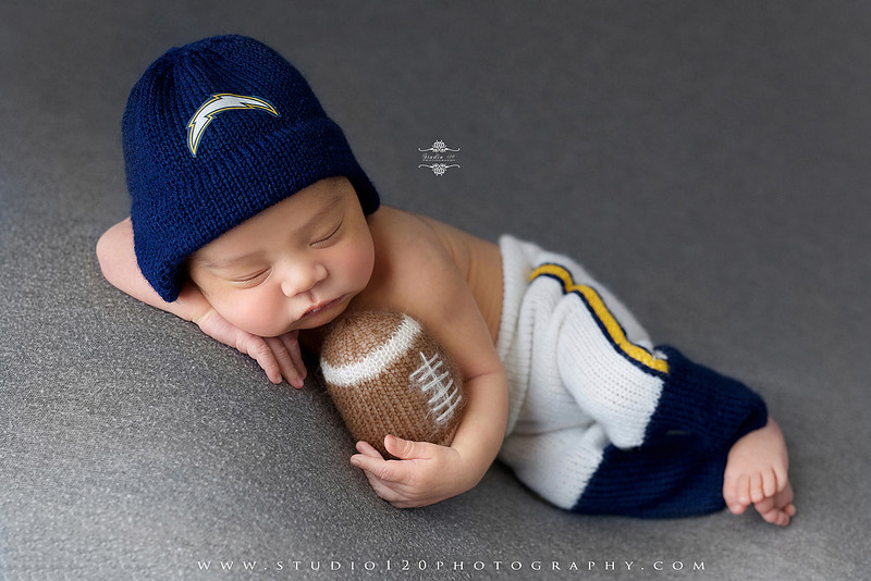 “newborn baby football themed photo with mini football and green turf backdrop”
“adorable infant posed with football props celebrating Super Bowl 2026 newborn session”
“sports baby photography football style end zone setup newborn portrait”