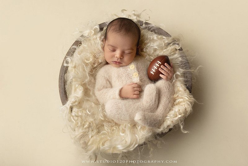 “newborn baby football themed photo with mini football and green turf backdrop”
“adorable infant posed with football props celebrating Super Bowl 2026 newborn session”
“sports baby photography football style end zone setup newborn portrait”