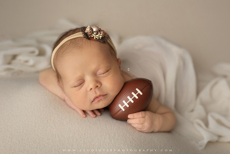 “newborn baby football themed photo with mini football and green turf backdrop”
“adorable infant posed with football props celebrating Super Bowl 2026 newborn session”
“sports baby photography football style end zone setup newborn portrait”