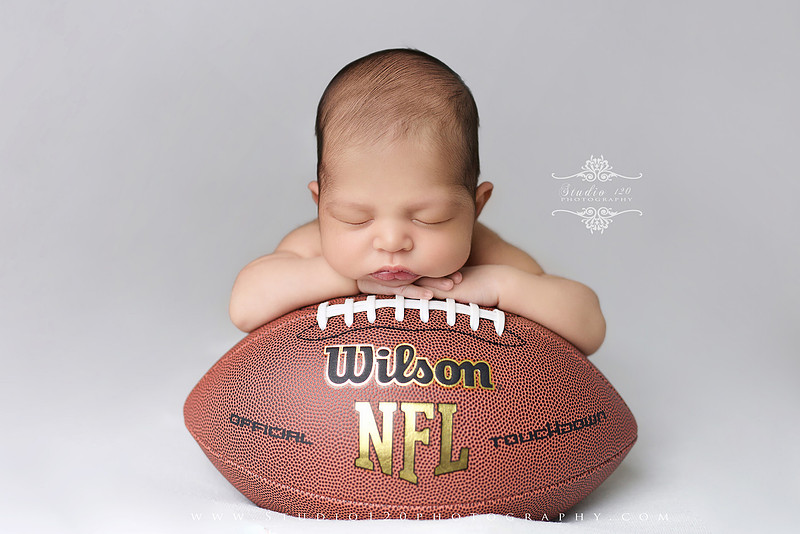“newborn baby football themed photo with mini football and green turf backdrop”
“adorable infant posed with football props celebrating Super Bowl 2026 newborn session”
“sports baby photography football style end zone setup newborn portrait”