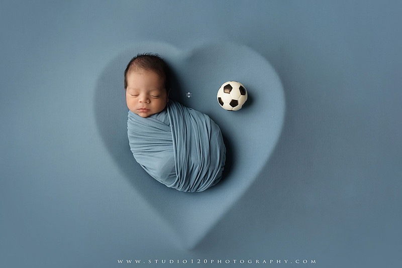 “newborn baby soccer themed photo holding black and white soccer ball”
“soccer sports newborn portrait with baby curled around soccer ball”
“infant soccer photography session with classic soccer ball and soft wrap”