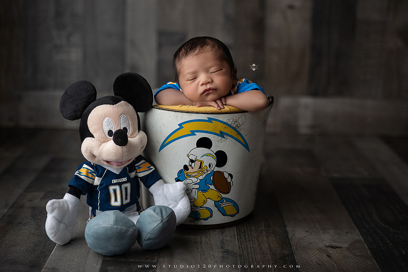 “newborn baby football themed photo with mini football and green turf backdrop”
“adorable infant posed with football props celebrating Super Bowl 2026 newborn session”
“sports baby photography football style end zone setup newborn portrait”