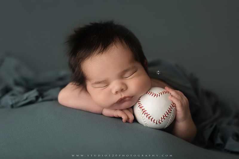 “newborn baby baseball photo with miniature bat and glove props”
“baseball themed newborn photography with baby and ball rustic sports setup”
“infant portrait styled with baseball, glove, and classic sports memorabilia”