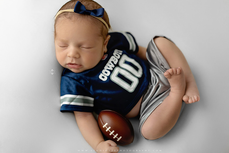 “newborn baby football themed photo with mini football and green turf backdrop”
“adorable infant posed with football props celebrating Super Bowl 2026 newborn session”
“sports baby photography football style end zone setup newborn portrait”