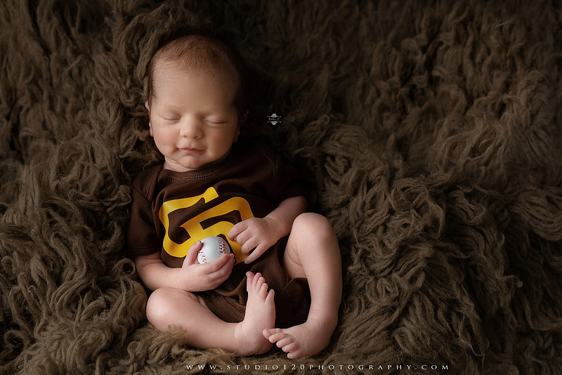 “newborn baby baseball photo with miniature bat and glove props”
“baseball themed newborn photography with baby and ball rustic sports setup”
“infant portrait styled with baseball, glove, and classic sports memorabilia”