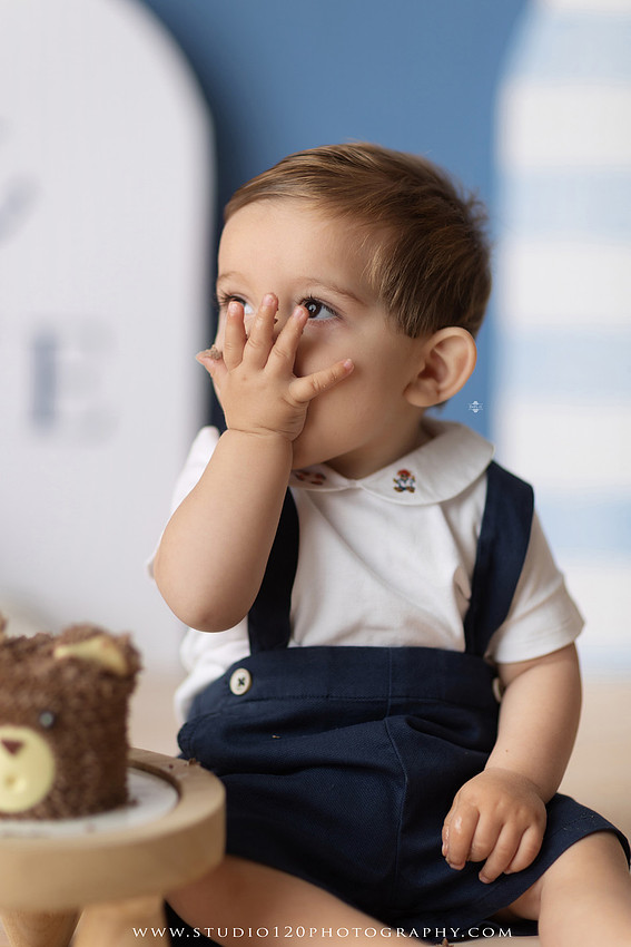 Boy's first birthday Ralph Lauren nautical cake smash session in San Diego featuring sailboats, teddy bears, and blue nautical décor.