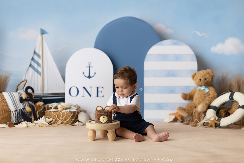 Boy's first birthday Ralph Lauren nautical cake smash session in San Diego featuring sailboats, teddy bears, and blue nautical décor.