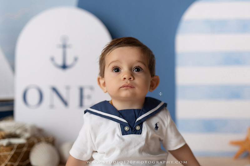 Boy's first birthday Ralph Lauren nautical cake smash session in San Diego featuring sailboats, teddy bears, and blue nautical décor.