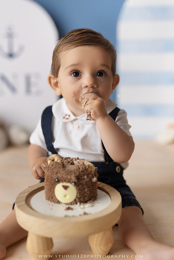 Boy's first birthday Ralph Lauren nautical cake smash session in San Diego featuring sailboats, teddy bears, and blue nautical décor.