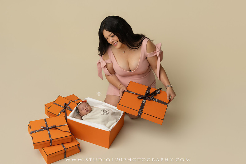 Hermès inspired newborn photography featuring baby girl posed in luxury orange gift box setup at Studio 120 Photography in San Diego County.