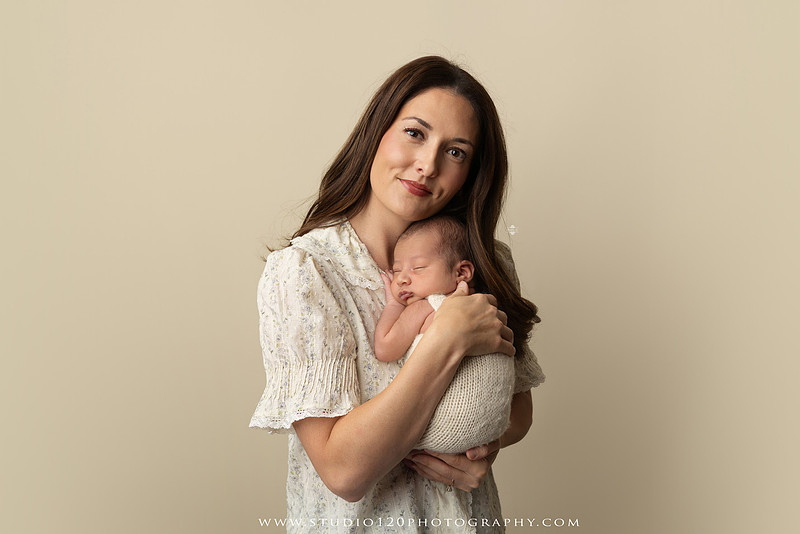 Parents cuddling their newborn baby boy during a family portrait session at Studio 120 Photography.