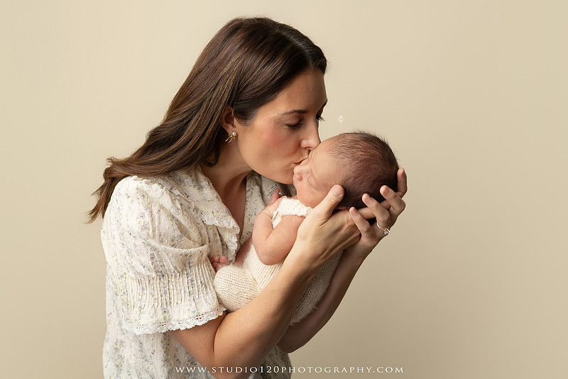 Parents cuddling their newborn baby boy during a family portrait session at Studio 120 Photography.