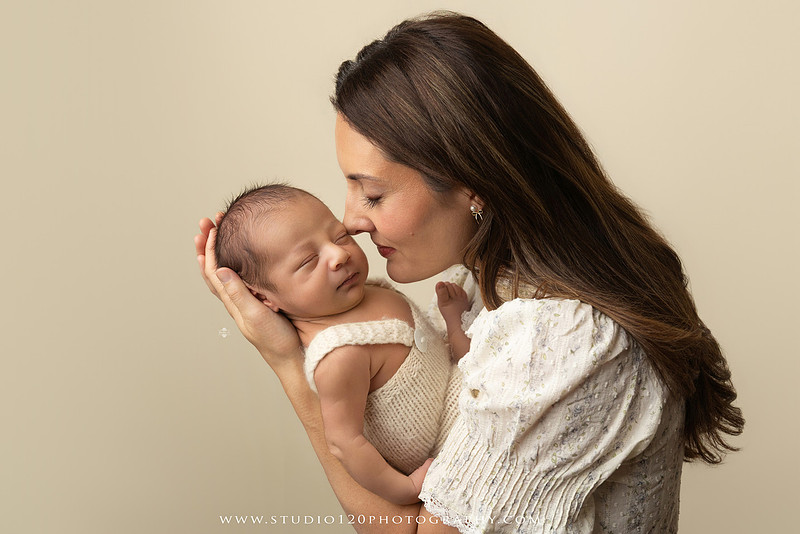 Parents cuddling their newborn baby boy during a family portrait session at Studio 120 Photography.