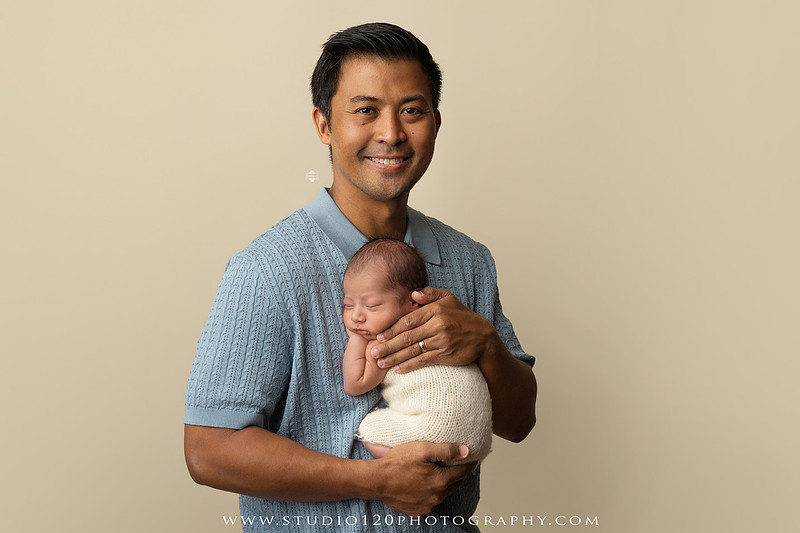Parents cuddling their newborn baby boy during a family portrait session at Studio 120 Photography.