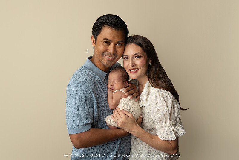 Parents cuddling their newborn baby boy during a family portrait session at Studio 120 Photography.