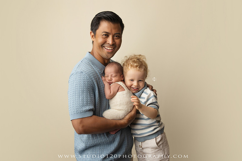 Parents cuddling their newborn baby boy during a family portrait session at Studio 120 Photography.