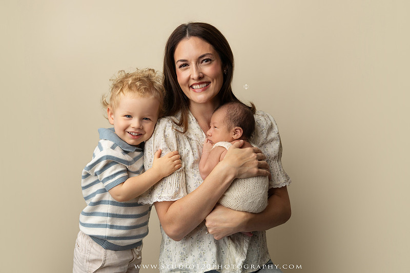 Parents cuddling their newborn baby boy during a family portrait session at Studio 120 Photography.