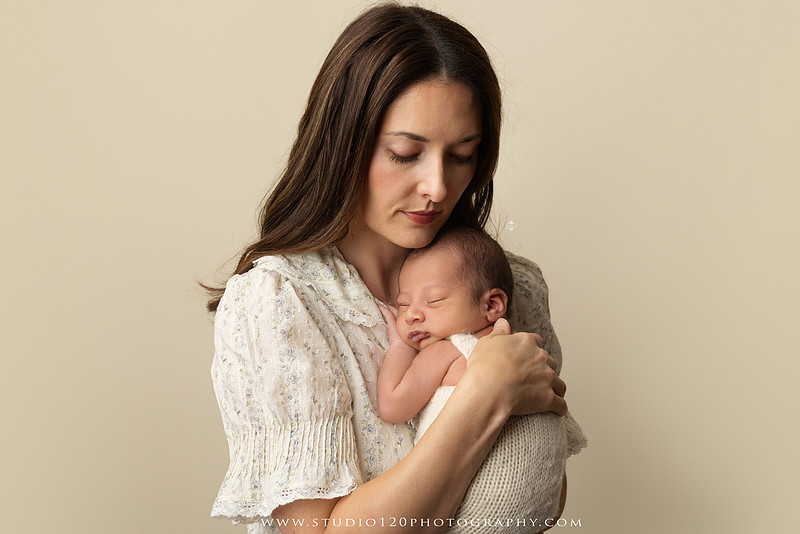 Parents cuddling their newborn baby boy during a family portrait session at Studio 120 Photography.