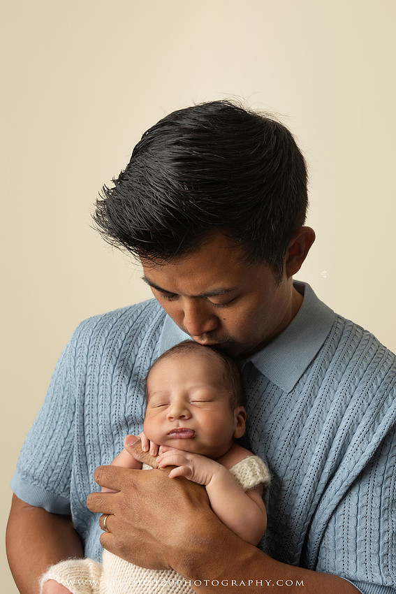 Parents cuddling their newborn baby boy during a family portrait session at Studio 120 Photography.