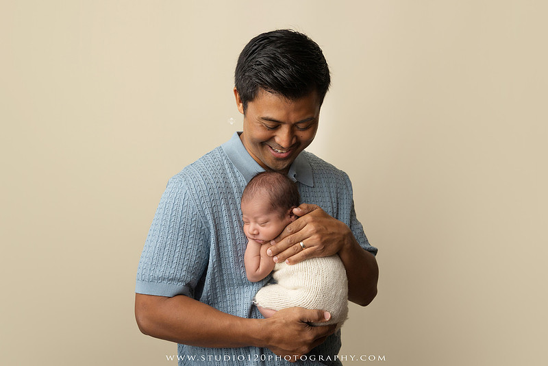 Parents cuddling their newborn baby boy during a family portrait session at Studio 120 Photography.