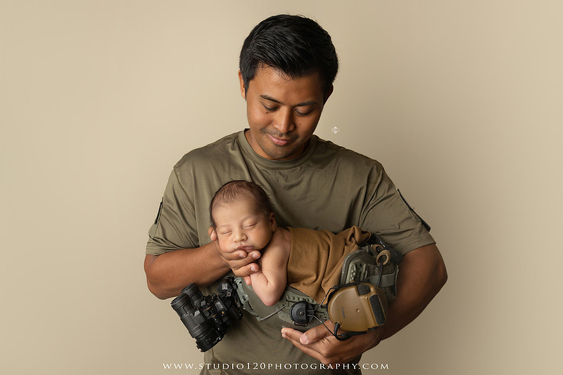 Parents cuddling their newborn baby boy during a family portrait session at Studio 120 Photography.