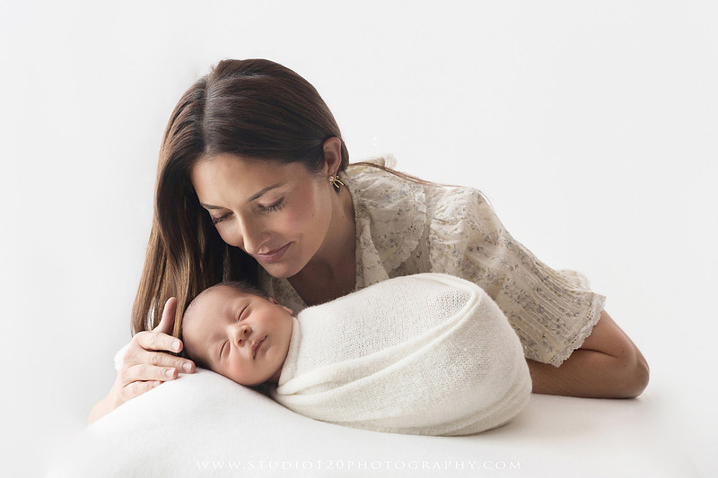 Parents cuddling their newborn baby boy during a family portrait session at Studio 120 Photography.