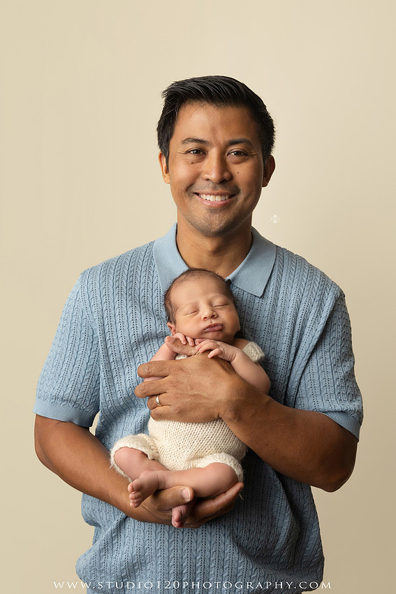 Parents cuddling their newborn baby boy during a family portrait session at Studio 120 Photography.