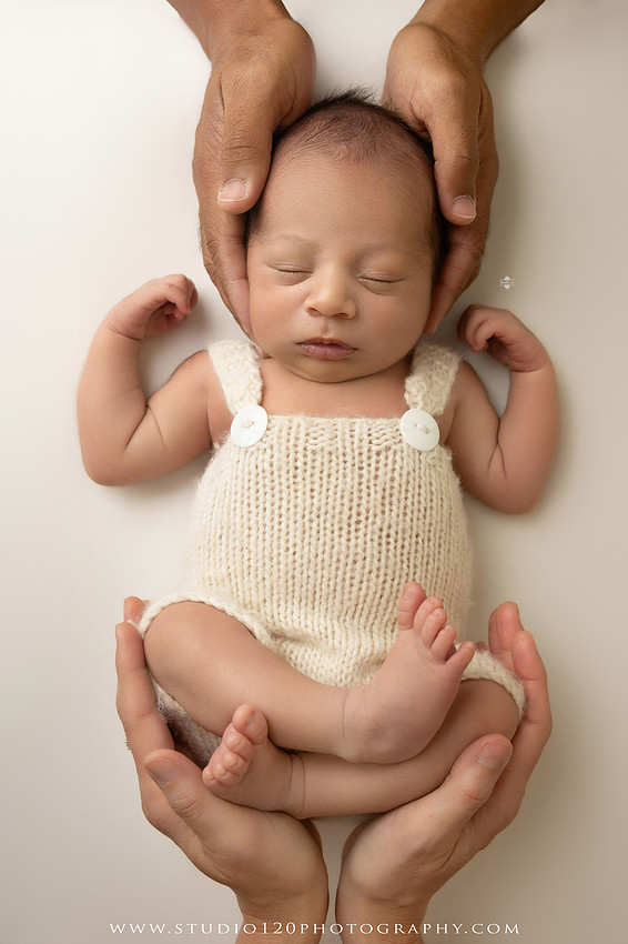 Parents cuddling their newborn baby boy during a family portrait session at Studio 120 Photography.