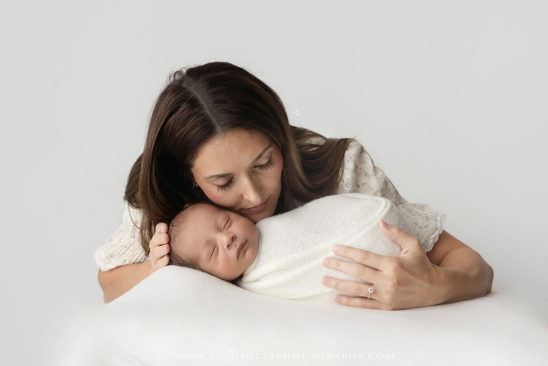 Parents cuddling their newborn baby boy during a family portrait session at Studio 120 Photography.