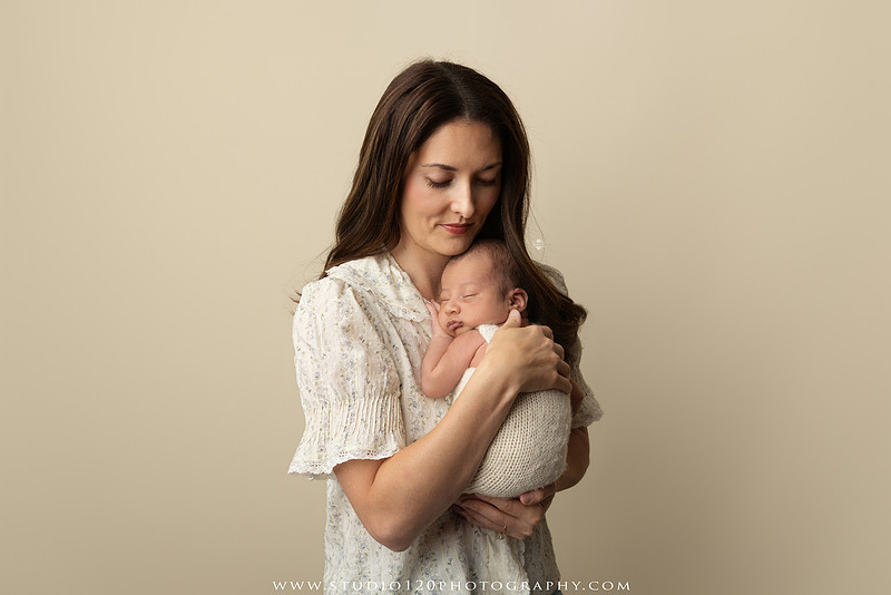 Parents cuddling their newborn baby boy during a family portrait session at Studio 120 Photography.