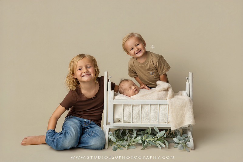 Professional newborn photography session in Ramona featuring a sleeping baby boy, sibling portraits, loving family photos, timeless neutral styling, wrapped newborn poses, and classic studio portraits by Studio 120 Photography.
