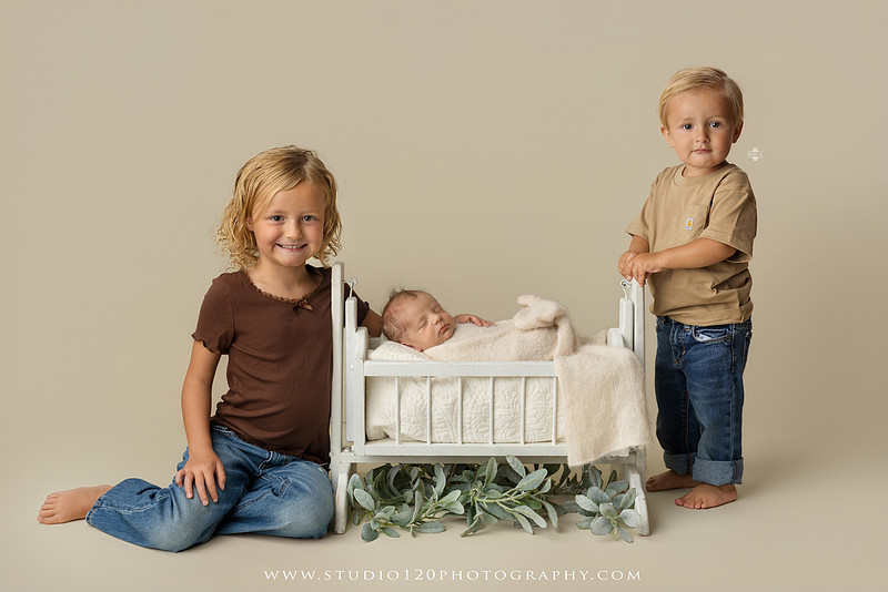 Professional newborn photography session in Ramona featuring a sleeping baby boy, sibling portraits, loving family photos, timeless neutral styling, wrapped newborn poses, and classic studio portraits by Studio 120 Photography.