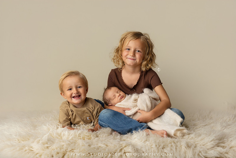 Professional newborn photography session in Ramona featuring a sleeping baby boy, sibling portraits, loving family photos, timeless neutral styling, wrapped newborn poses, and classic studio portraits by Studio 120 Photography.
