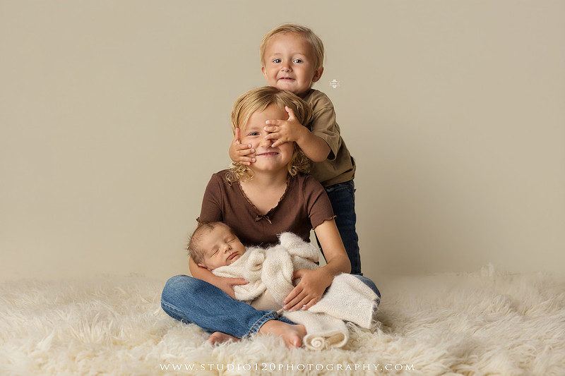 Professional newborn photography session in Ramona featuring a sleeping baby boy, sibling portraits, loving family photos, timeless neutral styling, wrapped newborn poses, and classic studio portraits by Studio 120 Photography.