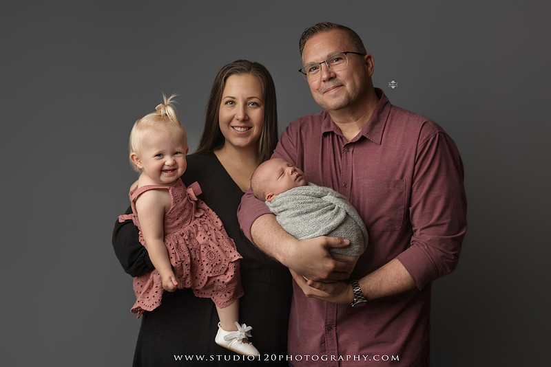 Professional newborn photography session in Ramona featuring a sleeping baby boy, sibling and family portraits, timeless wrapped newborn poses, custom racing-themed portraits, and classic studio photography by Studio 120 Photography.