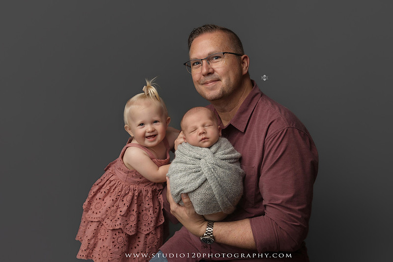 Professional newborn photography session in Ramona featuring a sleeping baby boy, sibling and family portraits, timeless wrapped newborn poses, custom racing-themed portraits, and classic studio photography by Studio 120 Photography.