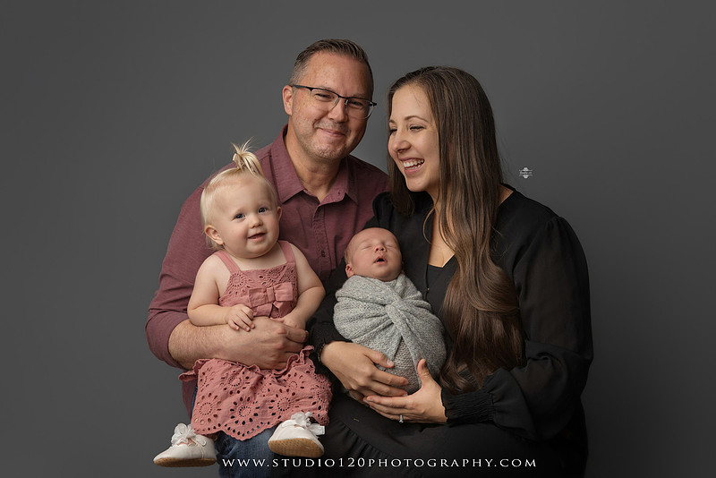 Professional newborn photography session in Ramona featuring a sleeping baby boy, sibling and family portraits, timeless wrapped newborn poses, custom racing-themed portraits, and classic studio photography by Studio 120 Photography.