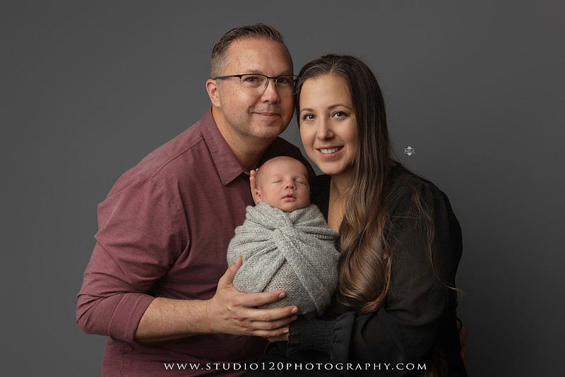 Professional newborn photography session in Ramona featuring a sleeping baby boy, sibling and family portraits, timeless wrapped newborn poses, custom racing-themed portraits, and classic studio photography by Studio 120 Photography.