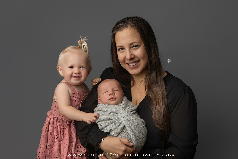 Professional newborn photography session in Ramona featuring a sleeping baby boy, sibling and family portraits, timeless wrapped newborn poses, custom racing-themed portraits, and classic studio photography by Studio 120 Photography.