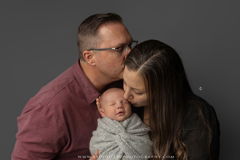 Professional newborn photography session in Ramona featuring a sleeping baby boy, sibling and family portraits, timeless wrapped newborn poses, custom racing-themed portraits, and classic studio photography by Studio 120 Photography.