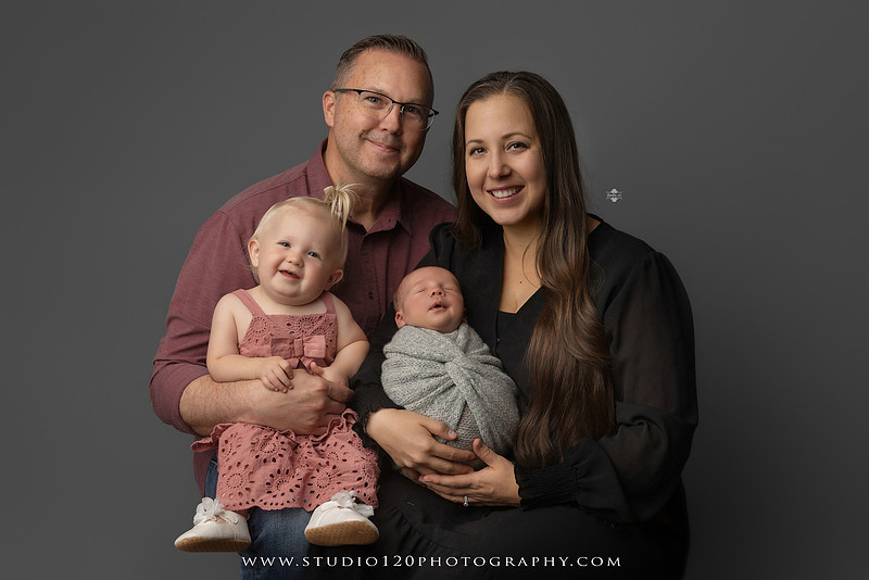 Professional newborn photography session in Ramona featuring a sleeping baby boy, sibling and family portraits, timeless wrapped newborn poses, custom racing-themed portraits, and classic studio photography by Studio 120 Photography.