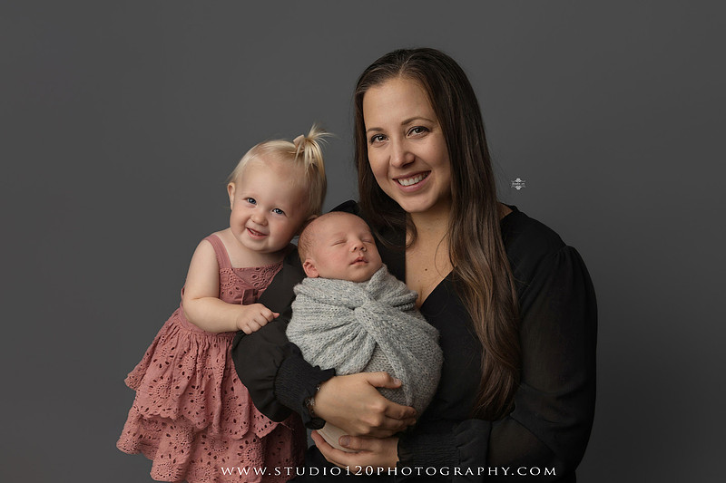 Professional newborn photography session in Ramona featuring a sleeping baby boy, sibling and family portraits, timeless wrapped newborn poses, custom racing-themed portraits, and classic studio photography by Studio 120 Photography.