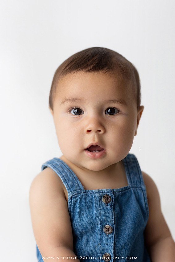 Baby boy sitter milestone portraits in Ramona photography studio featuring classic wooden toys, teddy bears, a vintage wooden bed, neutral props, natural textures, and timeless baby milestone photography capturing smiles, curiosity, and playful expressions.