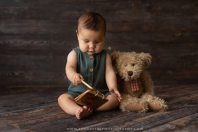 Baby boy sitter milestone portraits in Ramona photography studio featuring classic wooden toys, teddy bears, a vintage wooden bed, neutral props, natural textures, and timeless baby milestone photography capturing smiles, curiosity, and playful expressions.