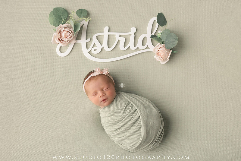 Professional newborn photography session featuring baby girl Astrid with custom Ramona Bulldogs football-themed portraits, a handcrafted Bulldogs newborn bucket wrap, football helmet and football, soft neutral newborn poses, vintage wooden bed with floral styling, plush bunny, blush and cream wraps, personalized 3D printed name sign, custom ASTRID letter artwork, and timeless studio newborn portraits by Studio 120 Photography in Ramona, CA.